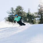 A person skiing down a snow-covered slope in New Hampshire.