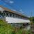 A covered bridge over a river in NH (New Hampshire).
